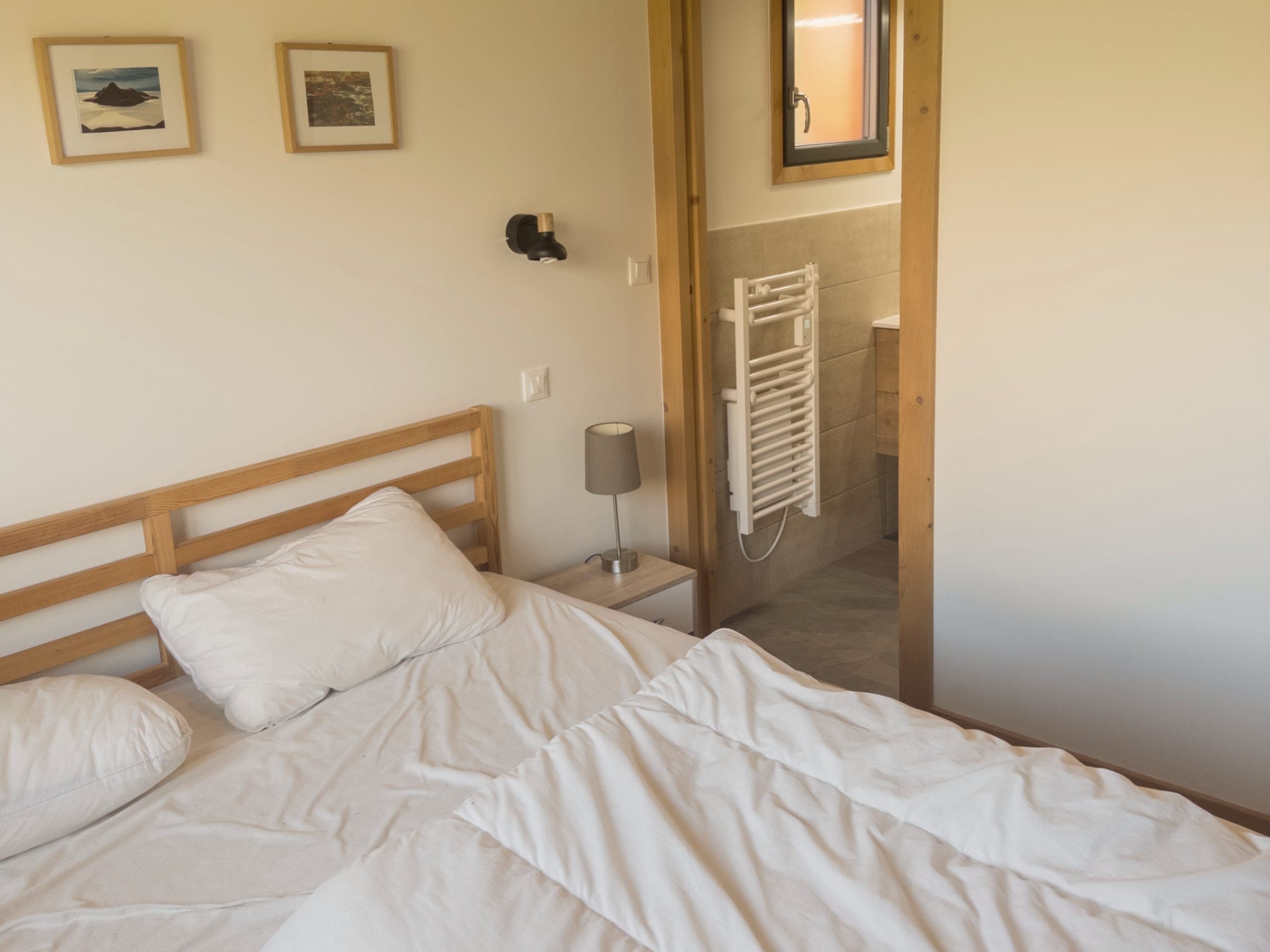La chambre avec sa salle de bain privée, porte ouverte